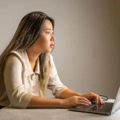 Młoda kobieta, data analyst, pracuje przy laptopie, analizując dane.